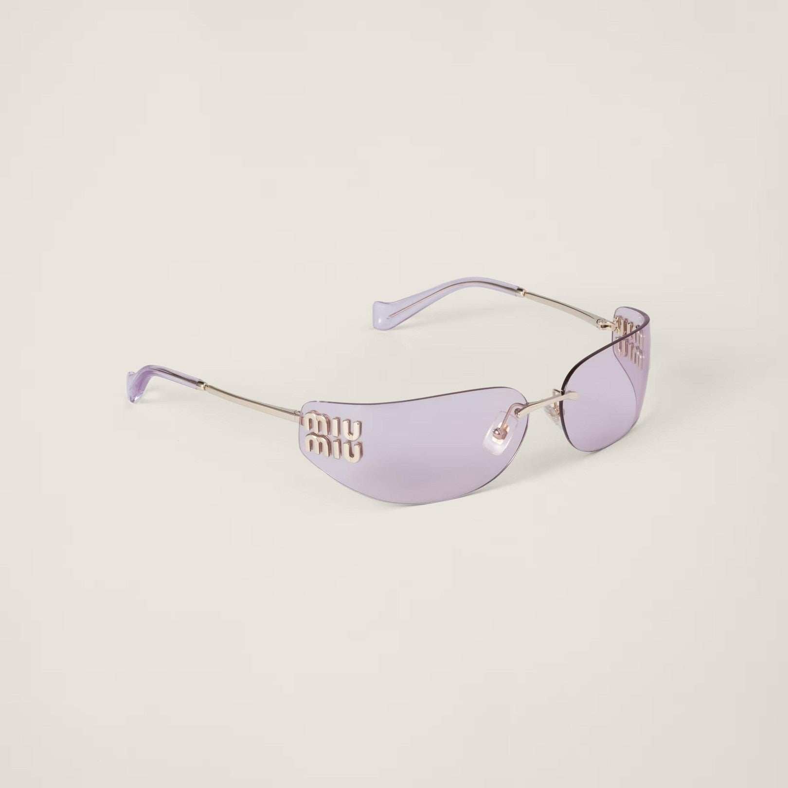 Image of Miu Miu metal sunglasses with frameless curved lenses and gold detailing.