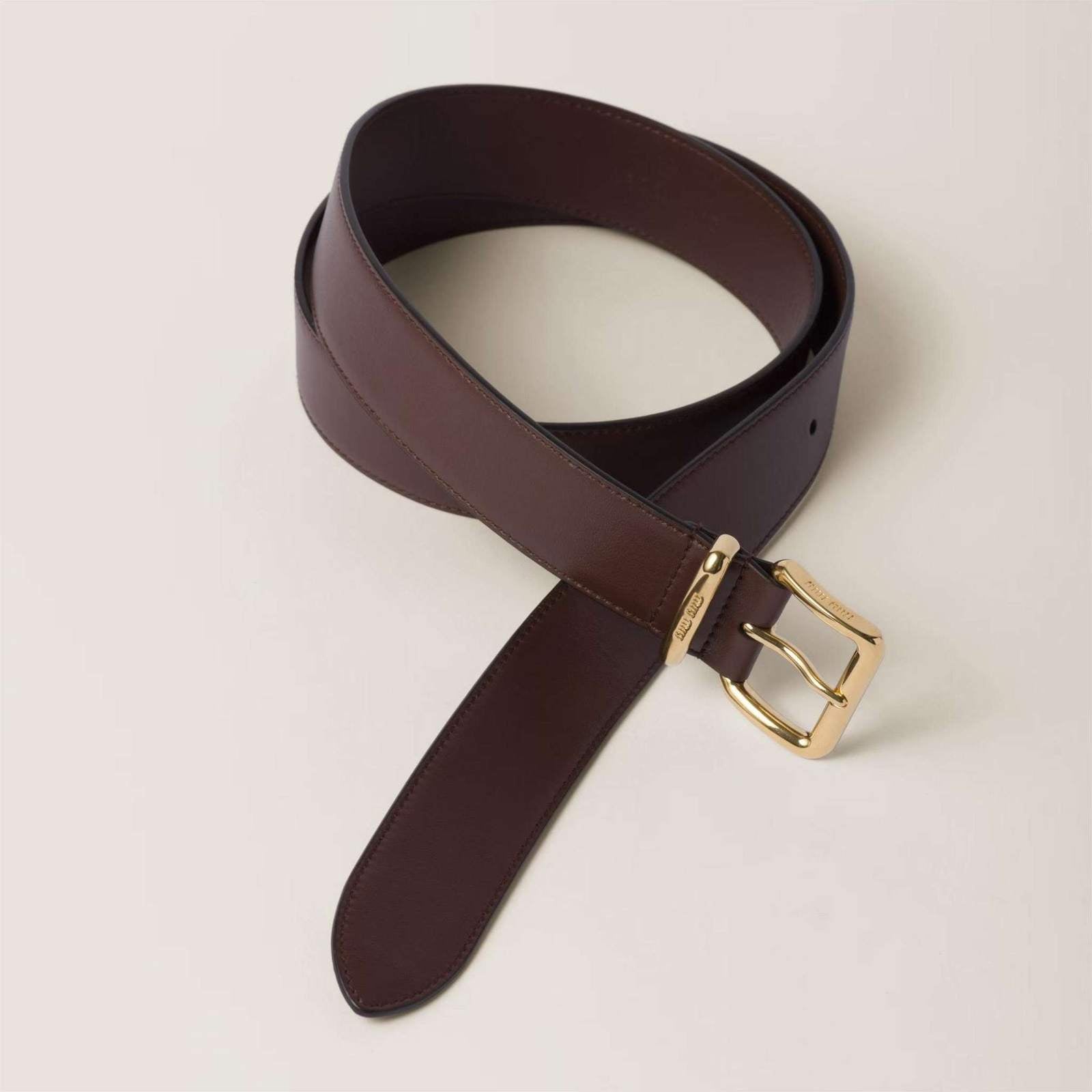 Image of חגורת עור Miu Miu חומה עם אבזם זהב לעיצוב יוקרתי ואופנתי.