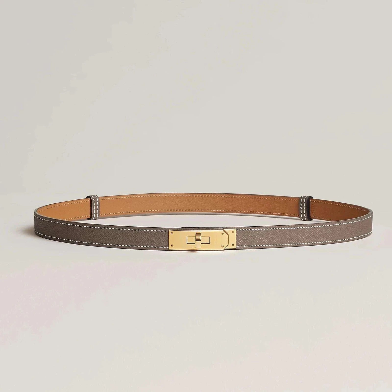 חגורת הרמס קלי מעור פרימיום עם אבזם מתכתי מוזהב, עיצוב יוקרתי.