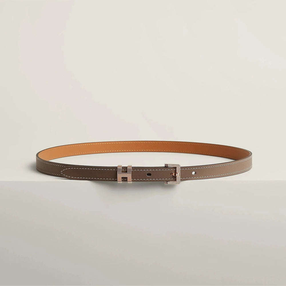 Hermes belt with elegant metallic buckle on white background.
