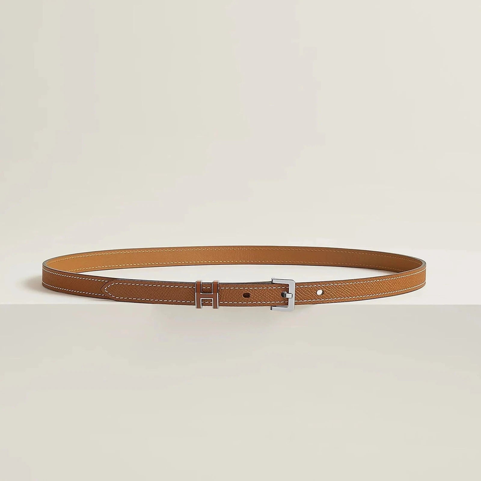 Luxurious Hermès leather belt with elegant metallic buckle, minimalist design, premium quality.