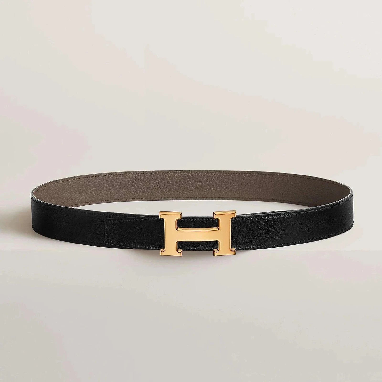 Luxurious Hermès leather belt with gold buckle, reversible design.