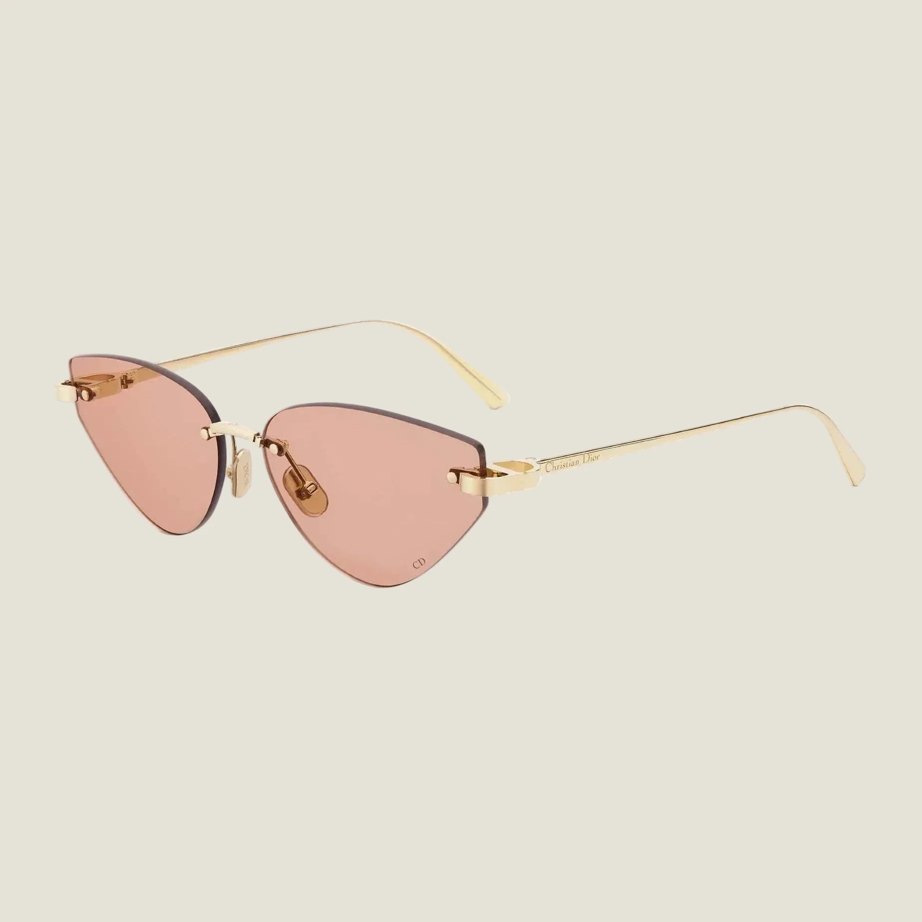 Image of Elegant cat-eye sunglasses with gold frames and rose-tinted lenses, embodying Dior's bold and feminine couture style.