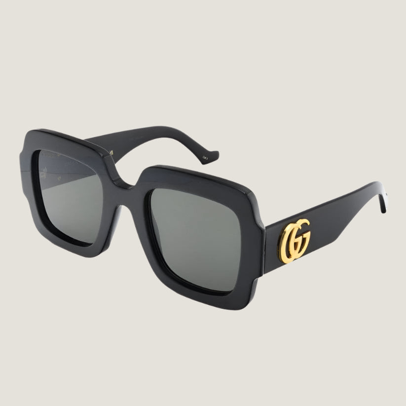 משקפי שמש GG של גוצ'י עם מסגרת שחורה ולוגו מוזהב.