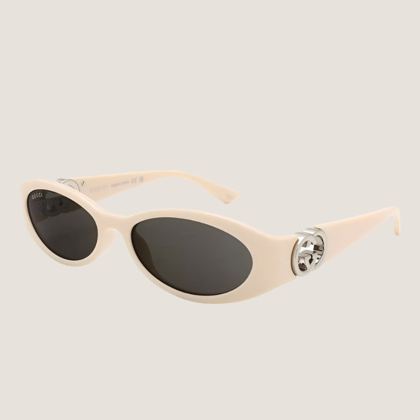 Image of GUCCI sunglasses with oval frames and metallic accents, luxury eyewear.
