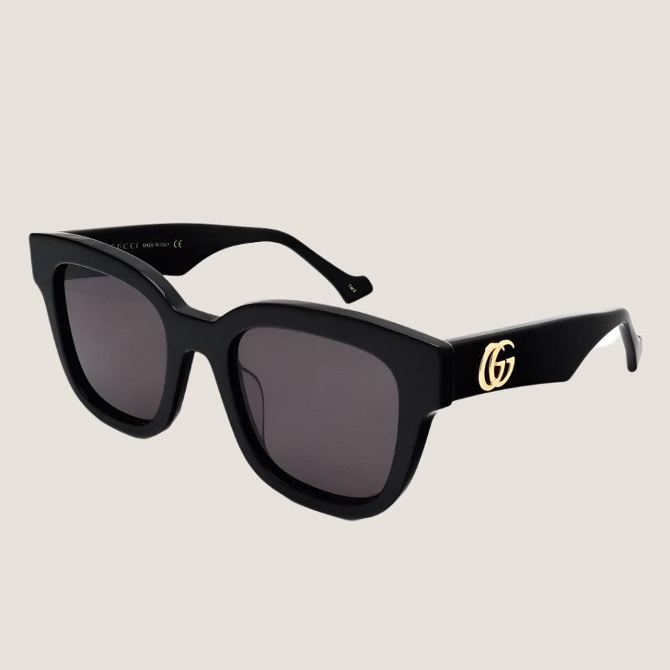 Gucci sunglasses with black frames and GG logo, luxury eyewear.