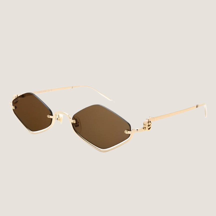 Designer Gucci sunglasses with gold frames and dark lenses, offering UV400 protection.