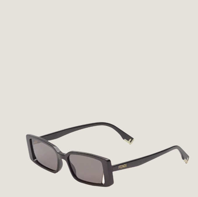 Image of Fendi sunglasses with black frames and dark lenses, featuring a gold logo on the arms.