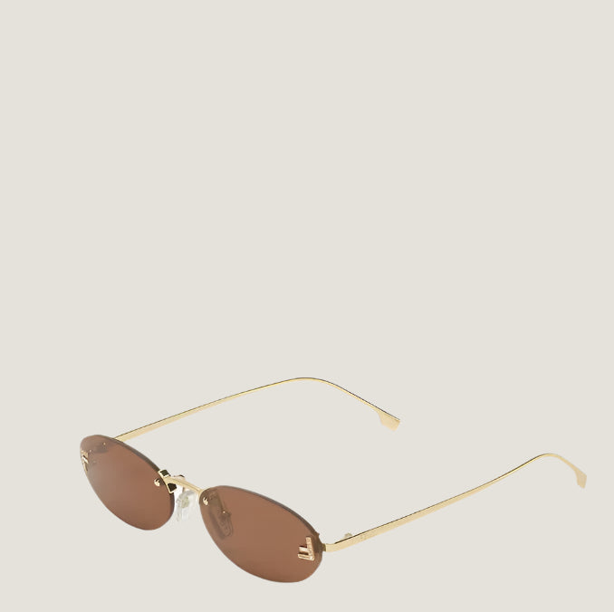 Fendi sunglasses with gold frames and brown lenses, embodying Roman luxury.