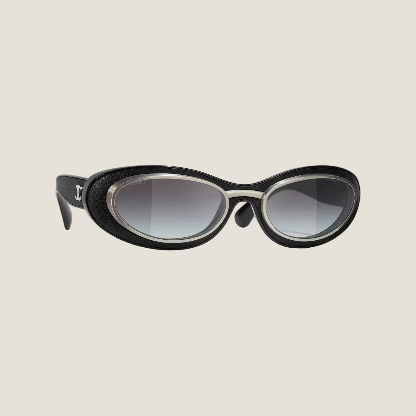 Image of CHANEL sunglasses, black and silver, plastic and metal frame, UVA/UVB protection, adjustable nose pads.