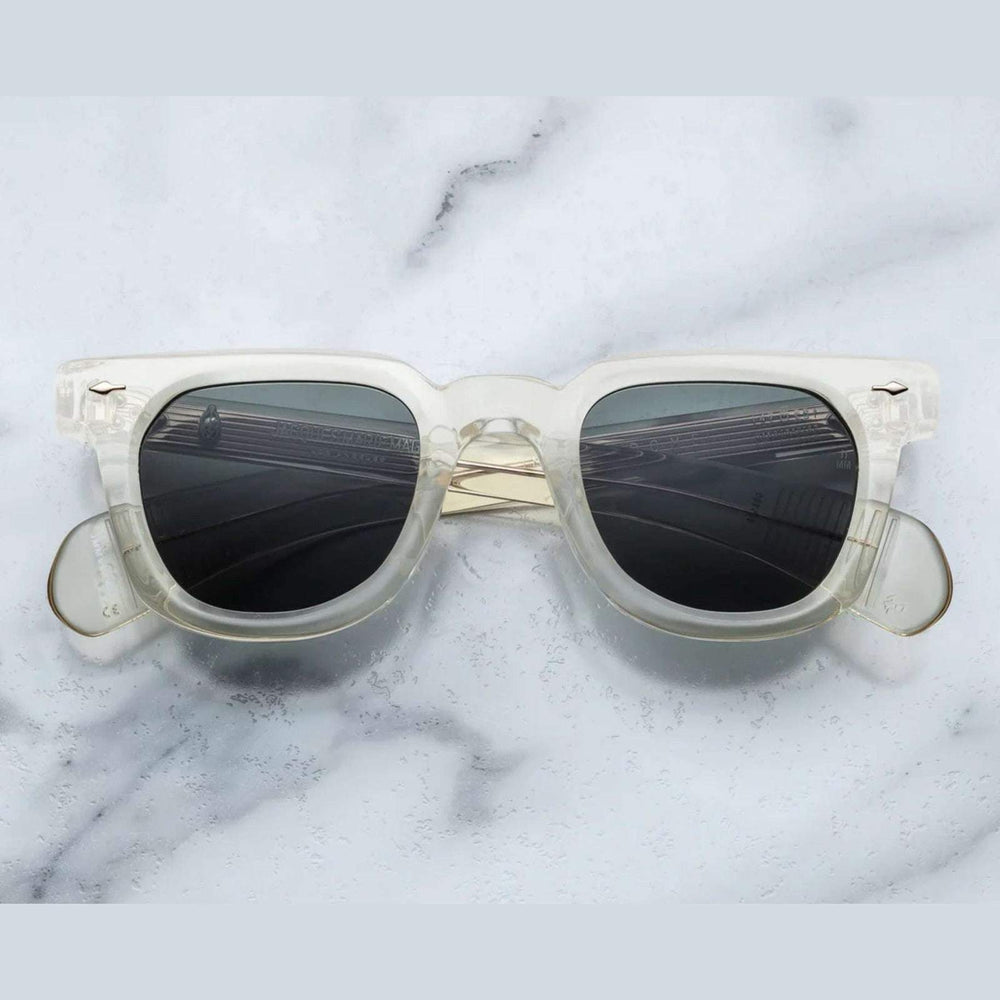 משקפי שמש Jacques Marie Mage בצבע שקוף שמנת, מסגרת פלסטיק, הגנה מלאה UVA/UVB, רפידות אף מתכווננות.