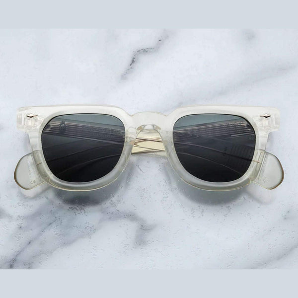 משקפי שמש Jacques Marie Mage בצבע שקוף שמנת, מסגרת פלסטיק, הגנה מלאה UVA/UVB, רפידות אף מתכווננות.